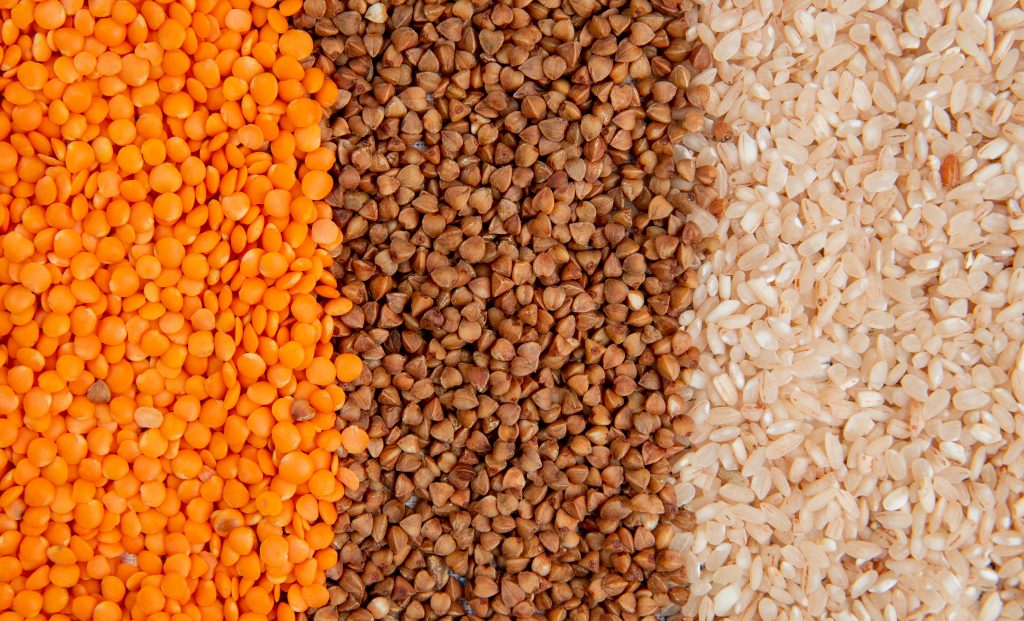 background of different types of groats red lentils buckwheat and rice top view