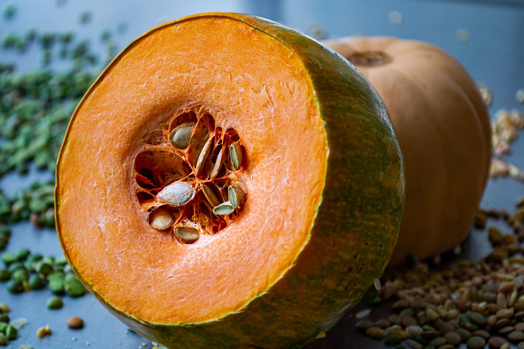 Photo by Santiago José Calvo High-quality close-up of a fresh pumpkin, emphasizing its seeds and vibrant color, perfect for healthy food themes.