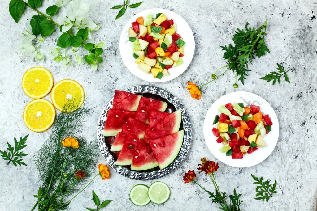 Inviting and colorful flat lay of fresh fruit slices and salads, showcasing a healthy and vibrant array of tropical flavors.